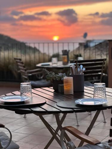 a table on a balcony with a sunset in the background at Maristel Hotel & Spa - Adults Only in Estellencs
