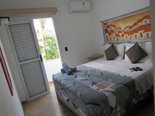 a bedroom with a bed and a door to a patio at Hotel Iracemar - Econômico in Guarujá