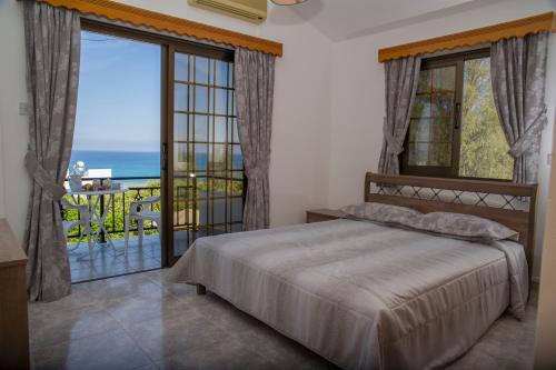 um quarto com uma cama e vista para o oceano em Savvas Villa em Argaka
