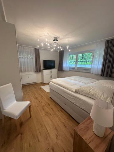 a large bedroom with a large bed and a chair at Sandy Coast Apartment Souterrain in Timmendorfer Strand