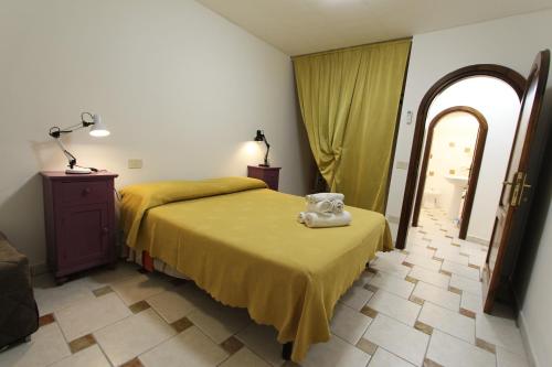 a bedroom with a bed with a yellow blanket on it at Casa Vacanze Il Granaio in SantʼOreste