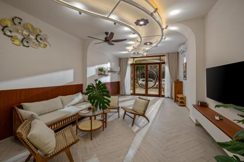 a living room with a couch and a tv at Shore House - Near My Khe Beach & City Centre by The Key in Da Nang
