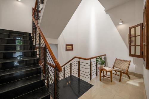 a staircase in a house with a chair and a table at Shore House - Near My Khe Beach & City Centre by The Key in Da Nang