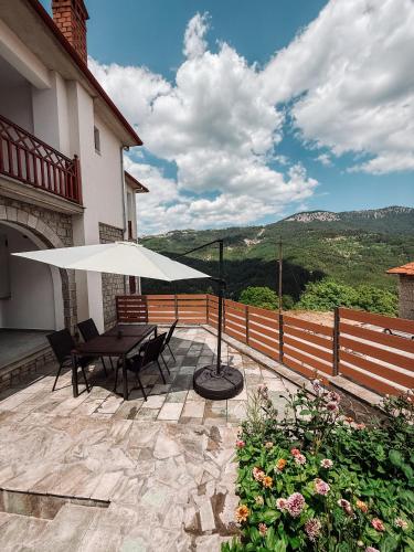 a patio with a table and an umbrella at Casa Lignum in Metsovo