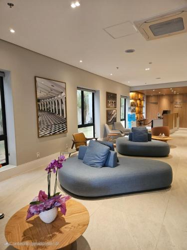 two beds in a living room with a table at Hotel Aeroporto Congonhas UH 116 com estacionamento in Sao Paulo