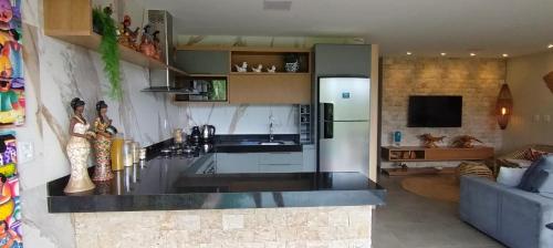 a kitchen with a counter top and a living room at Casa Santorini - Barra Grande - Maraú - Vila Kadosh in Barra Grande