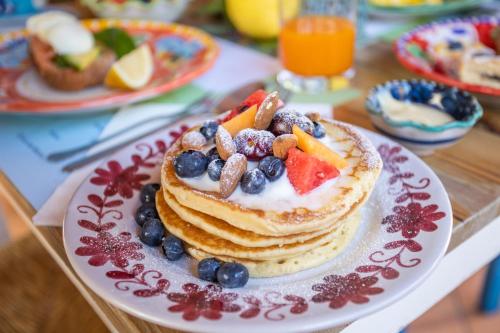 a plate of pancakes with fruit on a table at Casa Rosaria Amalfi Coast in Vietri sul Mare