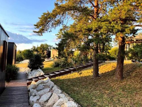 a wooden walkway leading to a yard with trees at Casa Slarku - Luxury Container Houses in Miskolc