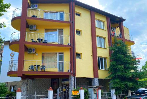 a yellow building with balconies on the side of it at Guest House Kostovi in Kiten