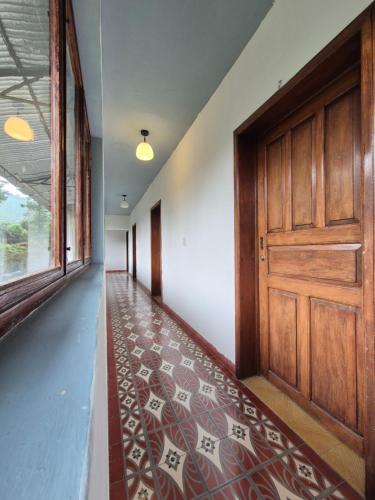 an empty hallway with a wooden door and a rug at Hotel Posada Doña Carito in Huahuaxtla