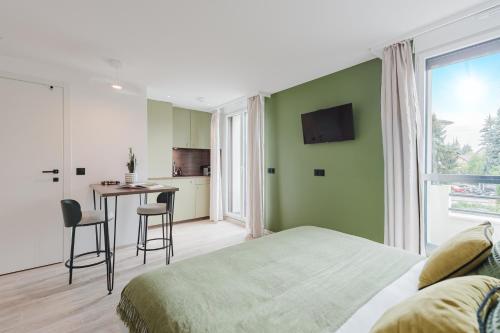 a bedroom with a bed and a table and a kitchen at Appart Hotel Neostelia in Annecy