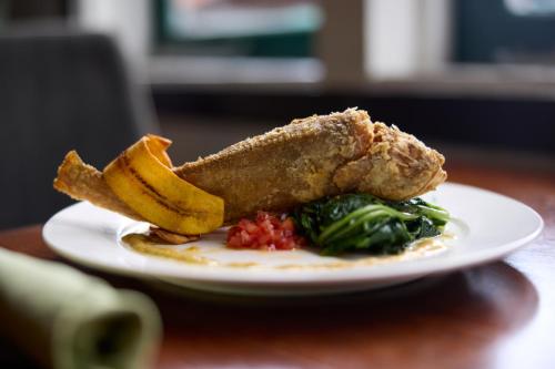 a plate of food with fried fish and chips and broccoli at Eco Torarica in Paramaribo