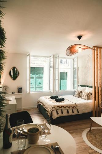 une chambre avec un lit et une table dans une pièce dans l'établissement La Loge Saumuroise - Centre-ville & Local vélo, à Saumur