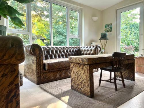 a living room with a couch and a table at Country Home in Idyllic South Downs - Views, Free Parking for 7 cars, Play room, Steam room, Fire Pit and more in Kingston near Lewes