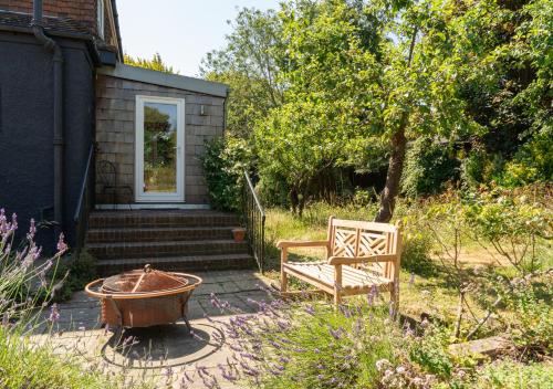 a bench and a tub in a yard next to a house at Country Home in Idyllic South Downs - Views, Free Parking for 7 cars, Play room, Steam room, Fire Pit and more in Kingston near Lewes