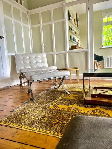 a living room with a white bench and a rug at Country Home in Idyllic South Downs - Views, Free Parking for 7 cars, Play room, Steam room, Fire Pit and more in Kingston near Lewes