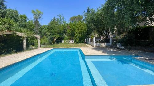 une grande piscine bleue dans une cour dans l'établissement Olaris - Appartement 2 chambres - Terrasse privée & Piscine partagée, à Bras