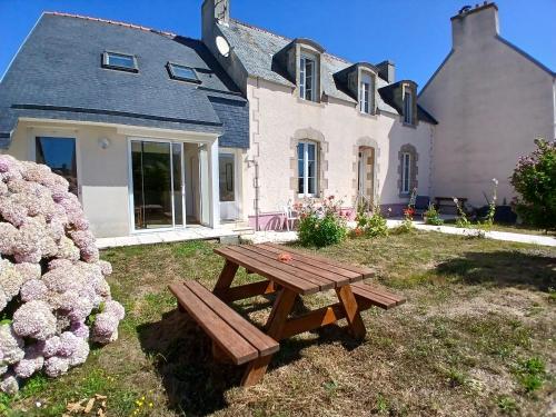 une table de pique-nique en bois devant une maison dans l'établissement Les pieds dans l eau, à Penmarcʼh