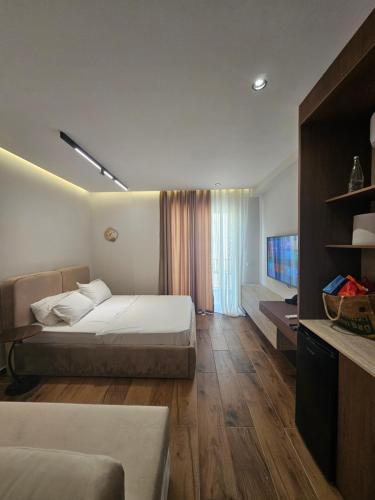 a hotel room with two beds and a television at Dejvid's Apartment in Polisi i Vogël