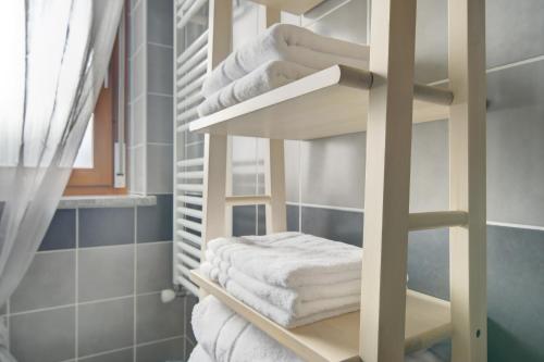 a stack of towels on a shelf in a bathroom at SGHouse appartamento con parcheggio gratuito in Rivoli