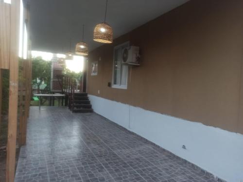 a hallway with a tile floor and two pendant lights at Cabañas Noscohue in Villa General Belgrano
