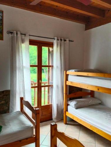 a room with three bunk beds and a window at La Borda de Ritort in Sort