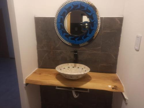a bathroom with a sink and a mirror on a wall at Cabañas Noscohue in Villa General Belgrano
