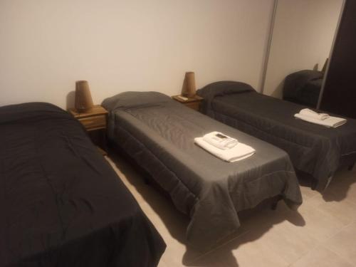 a room with two beds and a table at Cabañas Noscohue in Villa General Belgrano
