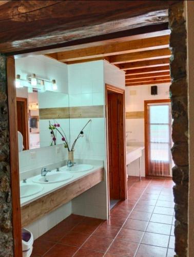 a bathroom with two sinks and a large mirror at La Borda de Ritort in Sort