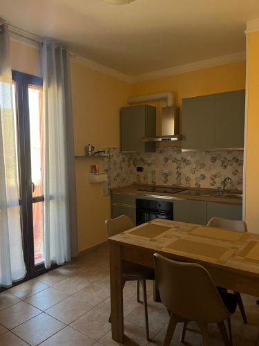 a kitchen with a wooden table and a dining room at Casa vacanze Sandalia in Bosa