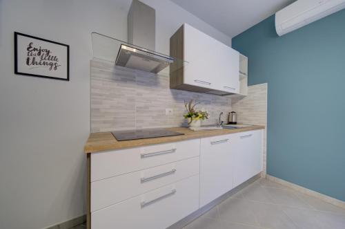 a kitchen with white cabinets and a sink at SGHouse appartamento con parcheggio gratuito in Rivoli