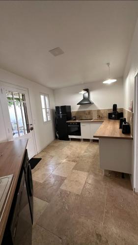 - une cuisine avec des murs blancs et un comptoir dans l'établissement Maison familiale centre ville, à Lamastre