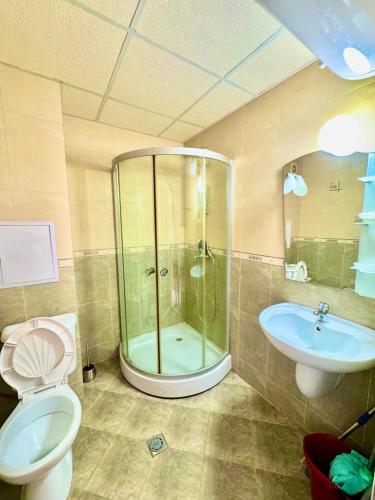 a bathroom with a shower and a toilet and a sink at Apartcomplex Grand Kamelia Sunny Beach in Sunny Beach