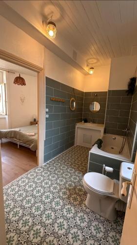 une salle de bain avec une baignoire, des toilettes et un lavabo dans l'établissement Maison familiale centre ville, à Lamastre