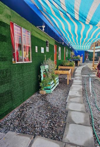 a building with a green wall with a blue ceiling at El valle in Copiapó