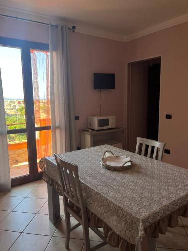 a table and chairs with a table and a microwave at Casa vacanze Sandalia in Bosa