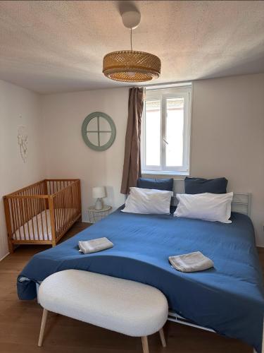 - une chambre avec un lit bleu, une chaise et une fenêtre dans l'établissement Maison familiale centre ville, à Lamastre