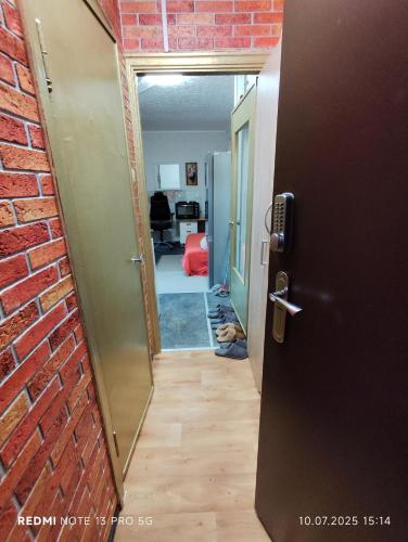 una porta aperta per una camera con muro di mattoni di своя комната в трёхкомнатной квартире или квартира целиком a Maardu