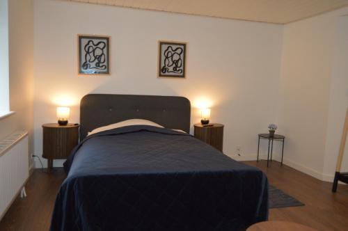 a bedroom with a bed with two lights on the wall at Serengeti & Stayover in Svebølle