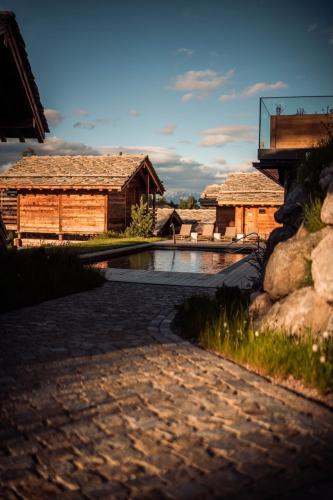 a stone walkway in front of two wooden buildings at MAD Retreat Hotel in Nendaz