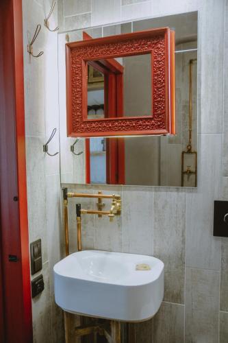 a bathroom with a white sink and a mirror at Old Believers Apartment in Rēzekne