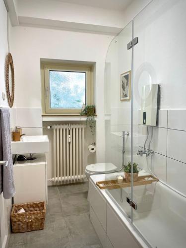 a white bathroom with a sink and a toilet at Apartment Rubens in Essen