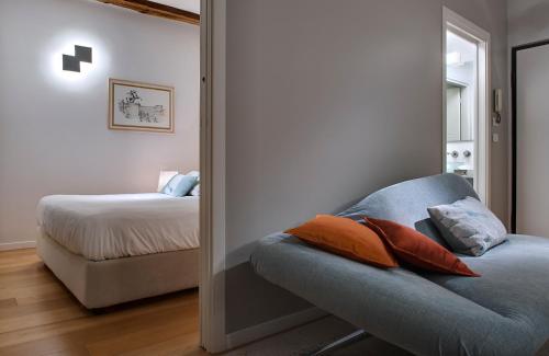 um quarto com uma cama e um sofá azul com almofadas em Piazza Vittorio Suites em Turim