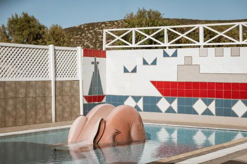 a swimming pool with two statues in the water at Dolphin Bay Seaside Resort & Suites in Galissas