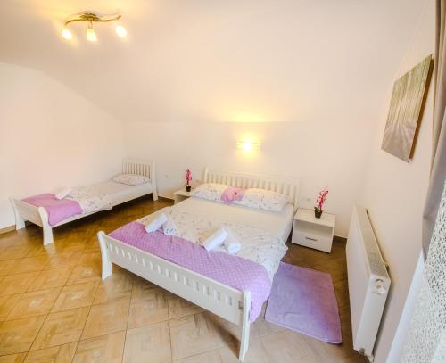 a bedroom with two beds with pink and white sheets at Guest House Mačić in Korenica