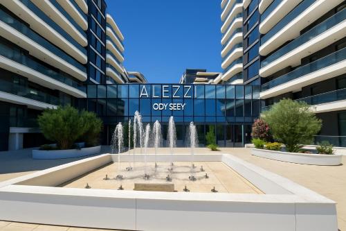 a fountain in front of an office building at Aparthotel C52 - Alezzi Odyssey Pool & Spa Resort in Mamaia Nord
