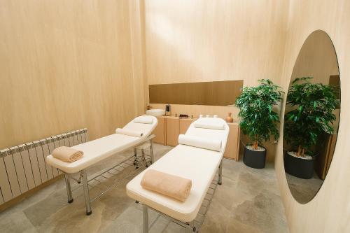 a waiting room with two examination tables and a mirror at Aparthotel C52 - Alezzi Odyssey Pool & Spa Resort in Mamaia Nord