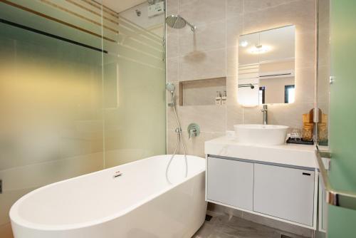 a white bathroom with a tub and a sink at Madison Urban Stay - Free Massage and Laundry in Hanoi