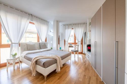 a bedroom with a large bed with white curtains at SuiteCentroStorico-Leaning Tower-Self check-in-AC in Pisa