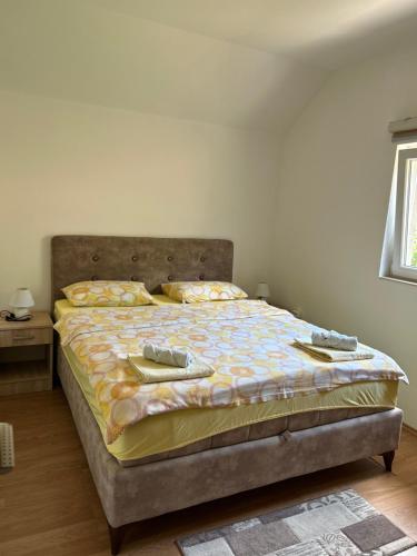 a bedroom with a bed with two shoes on it at Apartment Osmajic in Pluzine